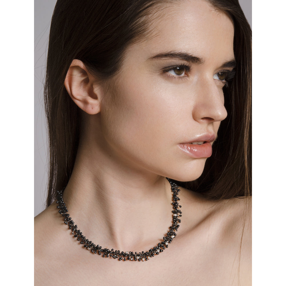 Model wearing a handmade oxidised silver and freshwater pearl choker. Sits just on the collar bone. Handmade by Yen Jewellery.