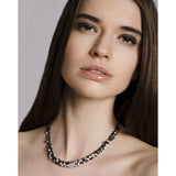 Model wears a handmade oxidised silver and freshwater pearl necklace. The chain is made up of hundreds of handmade silver droplets.