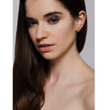 Model wears gold stud earrings handmade by Yen Jewellery