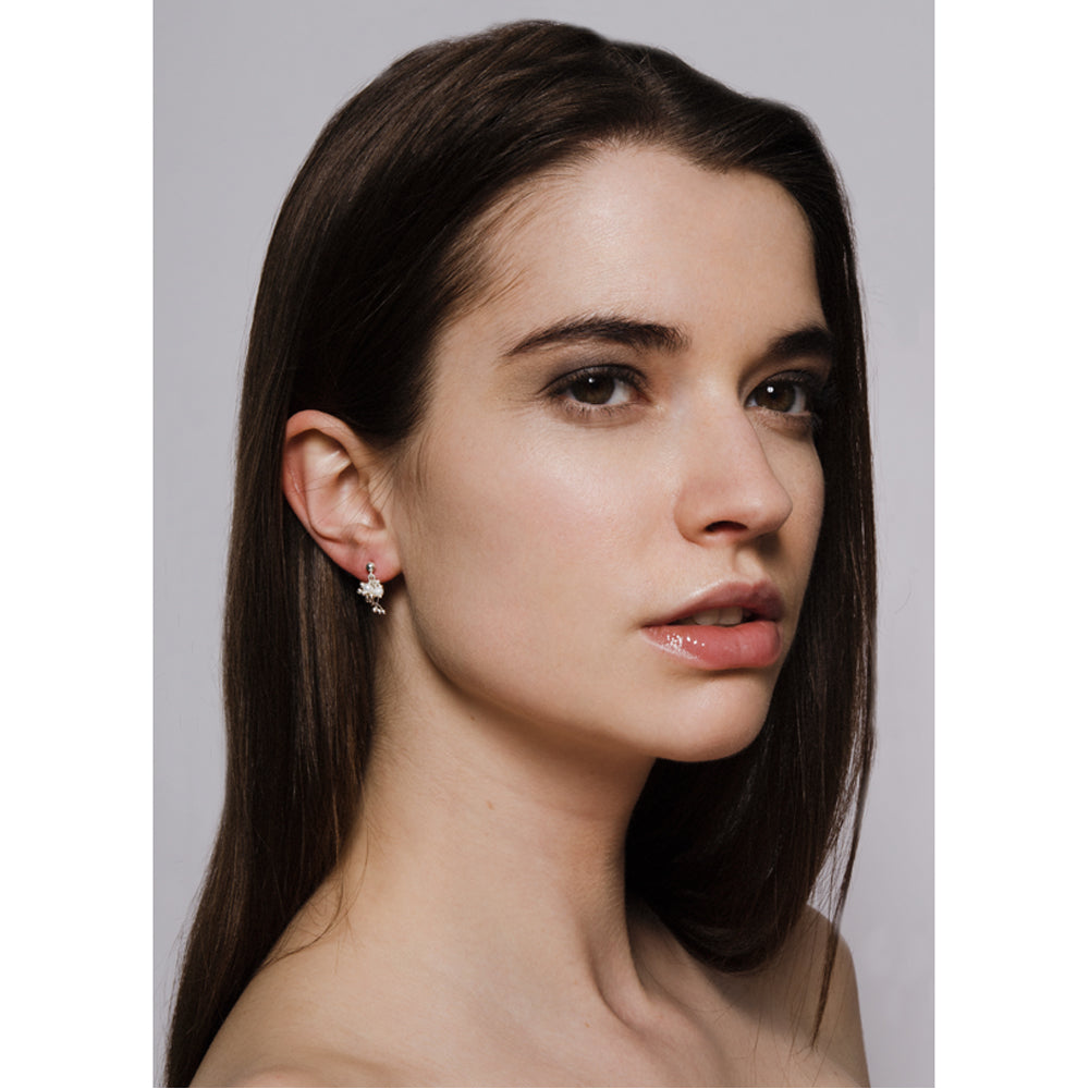 Model wears silver and pearl cluster stud earrings. Yen Jewellery